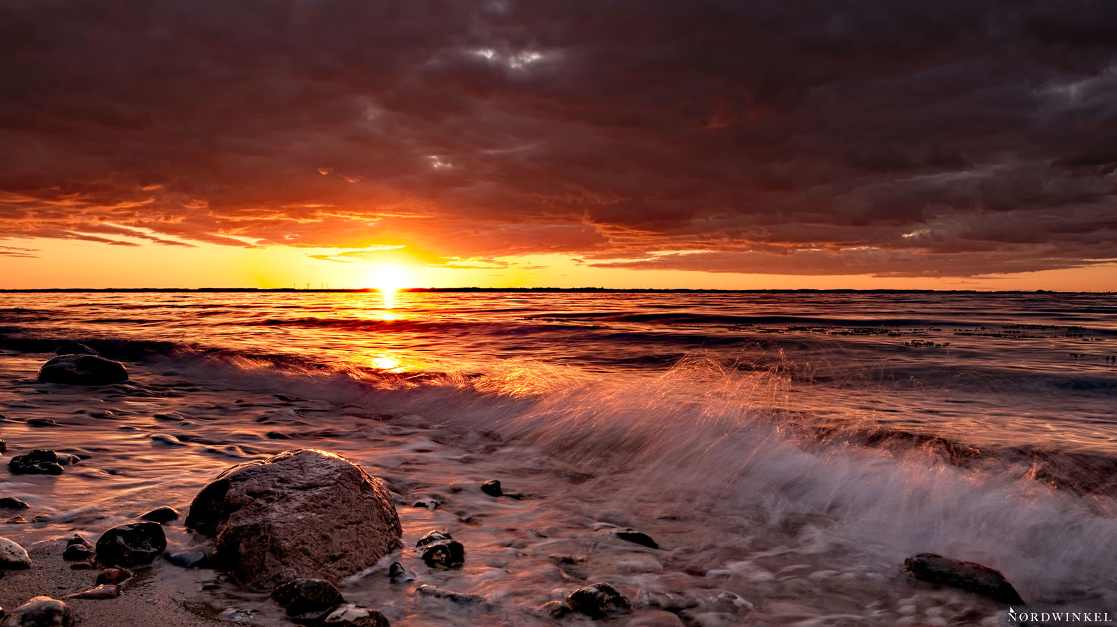 rauschende welle zum sonnenuntergang mit wolkendecke