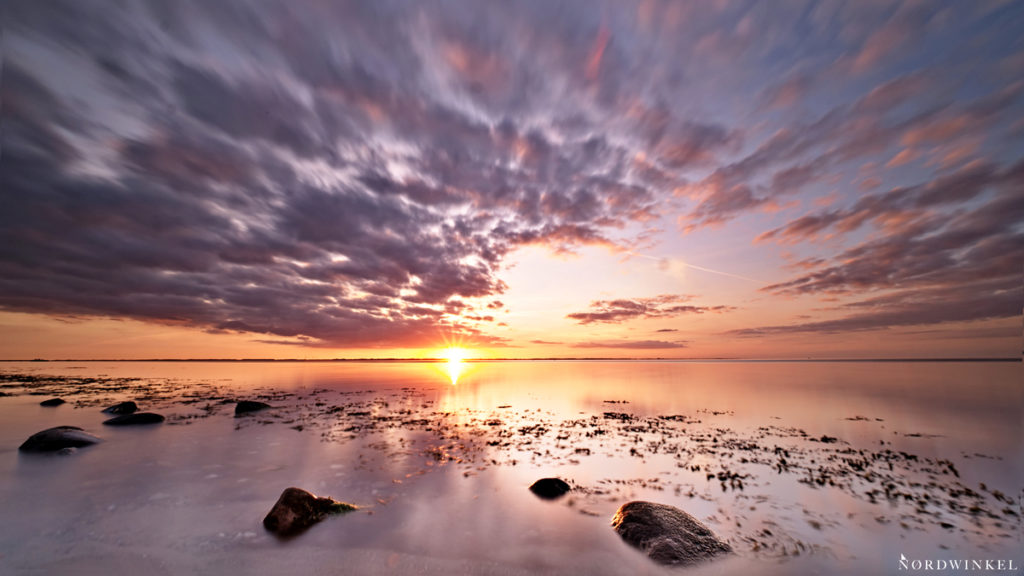 sonneuntergang an der ostseeküste mit steinen im vordergrund gegenbeispiel fotospruch nur originalobjektive
