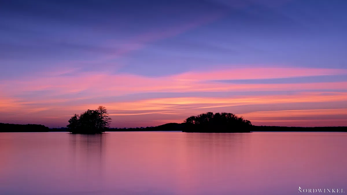 blau rot leuchtender abendhimmel am see mit zwei inseln als beispiel fürs malen mit licht