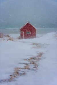 rotes holzhaus im schneesturm