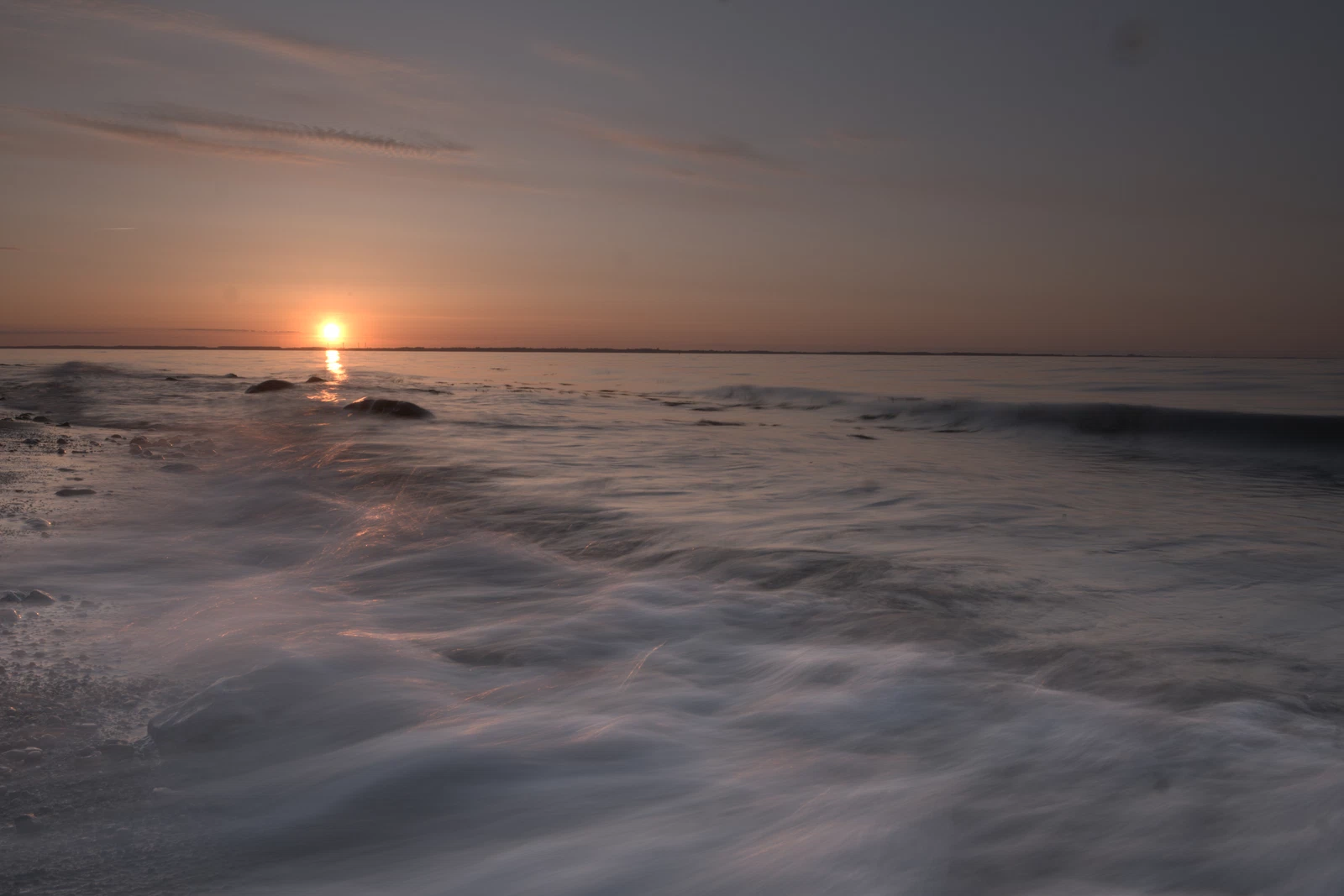 welle am ostseestrand zum sonnenuntergang