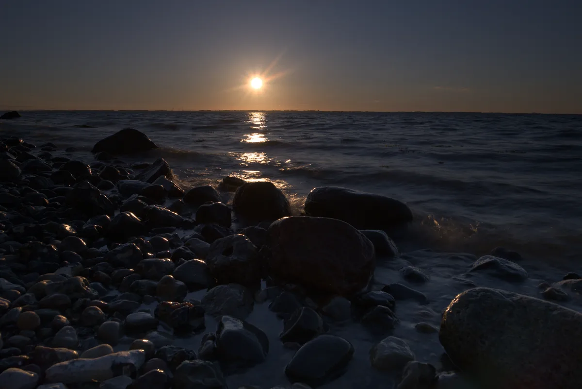 zu dunkel sonnenuntergang am steinstrand